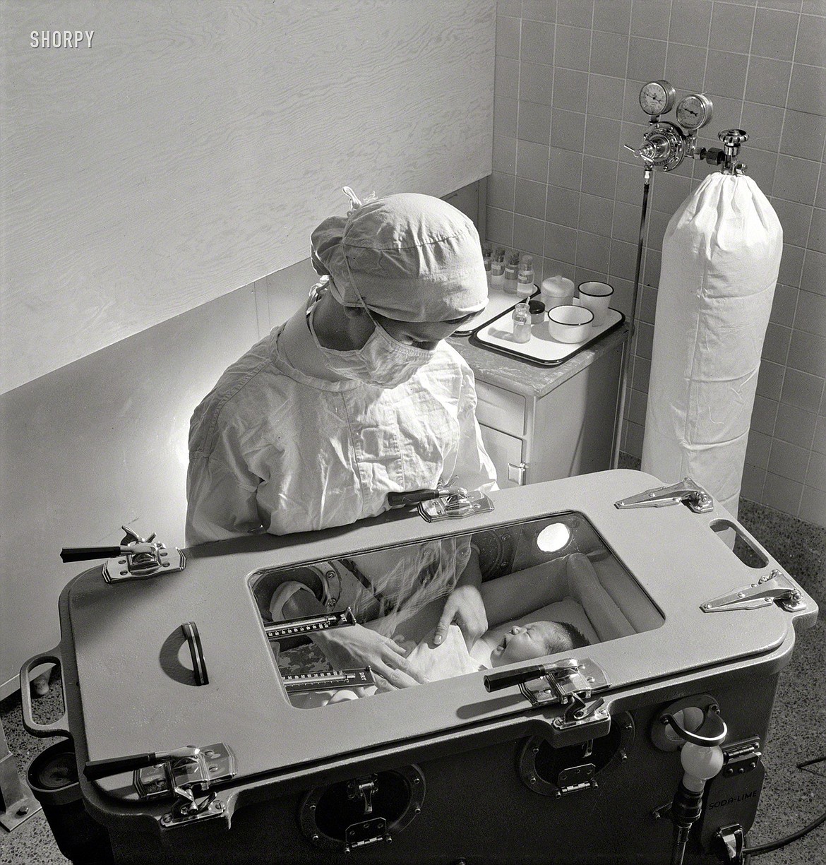 Nurse attending to a premature baby in “baby box” (1942).