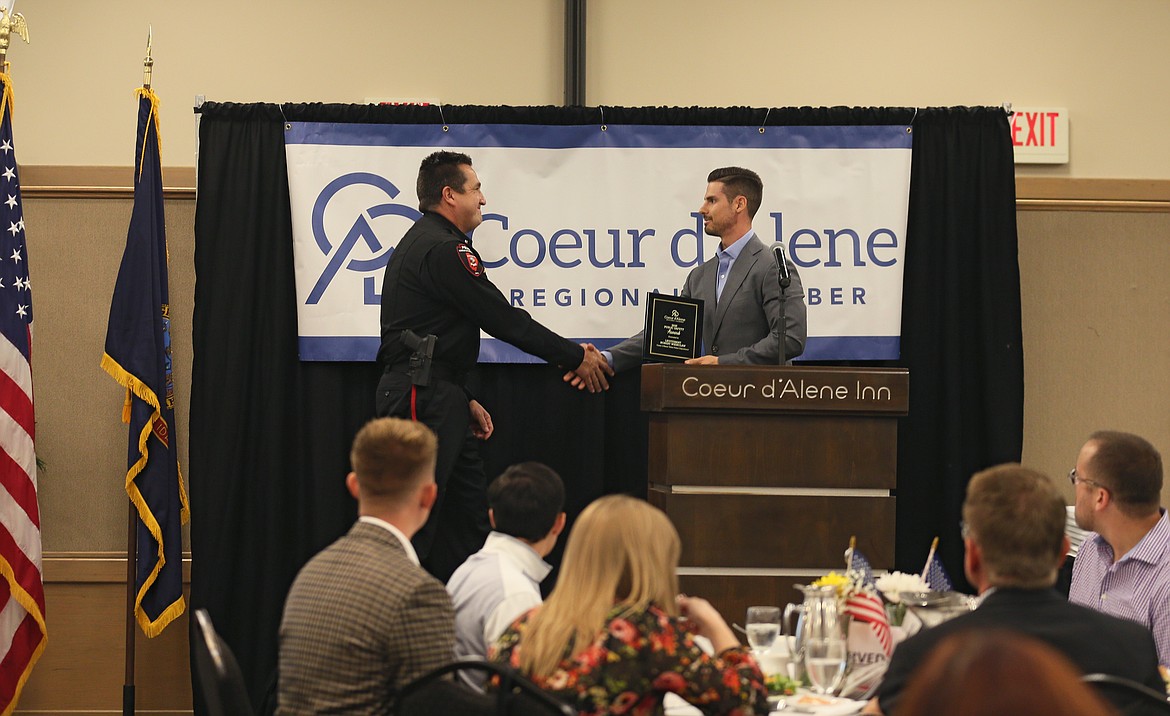 Coeur d'Alene Chamber President and CEO Derrell Hartwick shakes Coeur d’Alene Tribal Police Lt. Robert Wienclaw's hand as he presents him with an award on Wednesday.