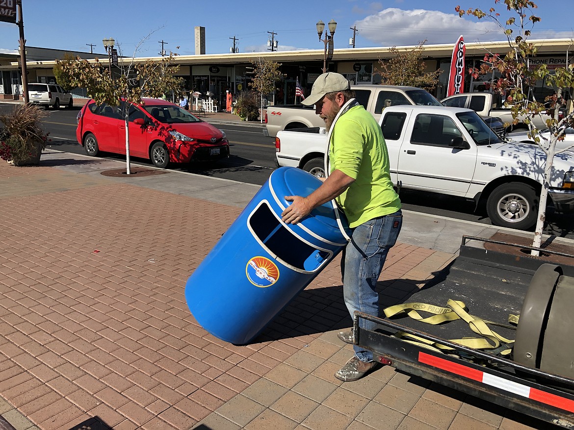 Moses Lake City maintenance worker Lee Willis gets ready to move a new trash receptacle Thursday morning.
