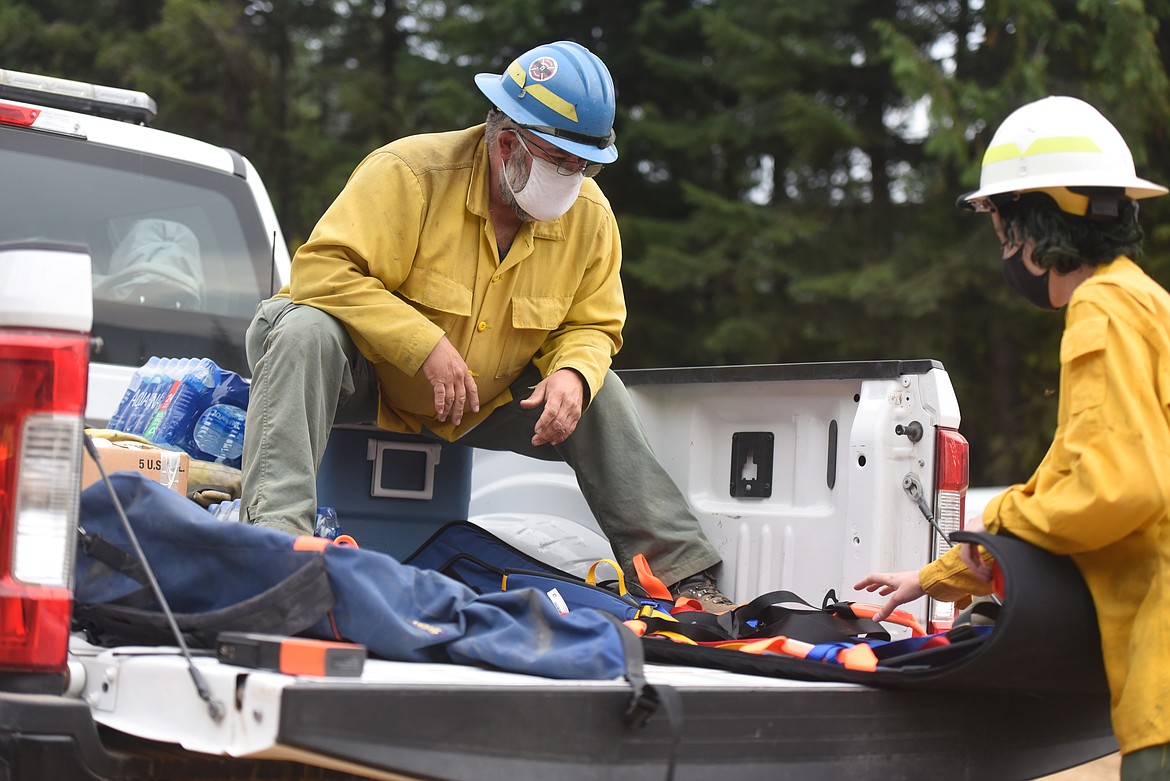 Shane Feightner, line safety officer, and Jess Tullis, fire line EMT, review a piece of extraction equipment near the edge of the Callahan Fire on Sept. 22.