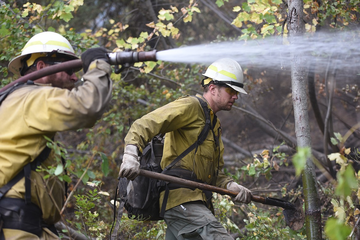 Eureka firefighters Justin Pilkington and Sam Westlin work along the edge of the Callahan Fire on Sept. 22. Pilkington worked a hose while Westlin used a rogue hoe to mop up the smoldering fire.