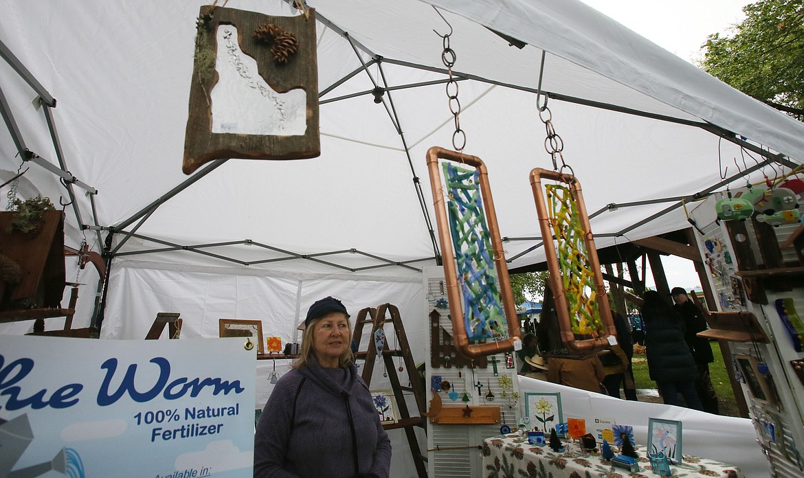 Betty Schneider is surrounded by creative crafts she and her husband Verle make for their business, Wood and Glass Creations, during the Athol Farmers Market Fall and Music Fest on Friday.