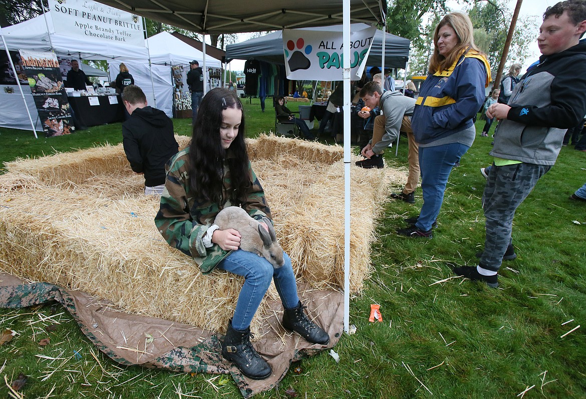 Presley Willis, 10, of Spirit Lake, chills with her Rex rabbit Fred during the Athol Farmers Market Fall and Music Fest. According to Presley, Rex rabbits are one of the softest rabbits in the world.