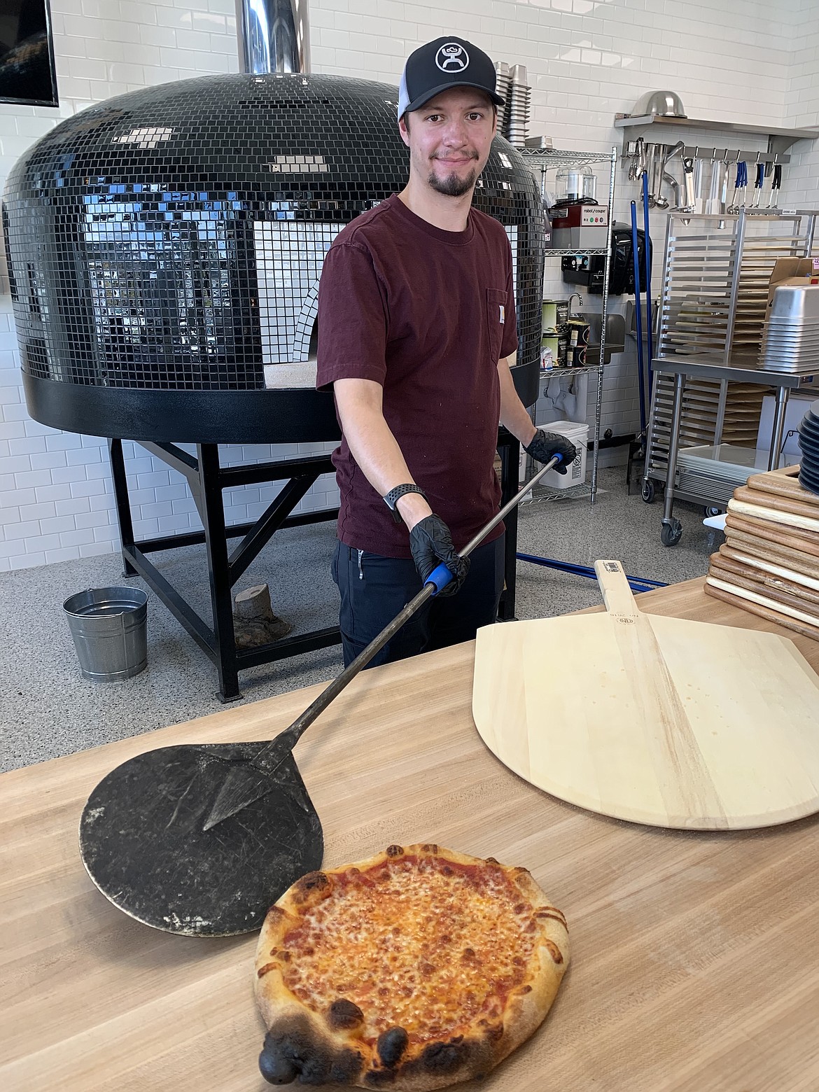 Courtesy photo
General Manager Thomas Cook prepares an order at Mangia Wood-Fired Pizza, which will open soon in The Northern complex at the Ramsey Road and Hanley Avenue intersection.