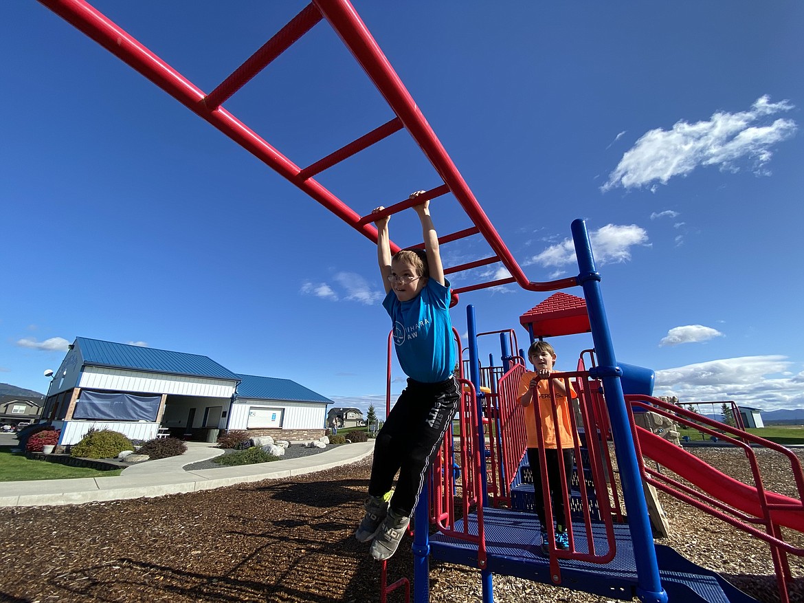 STEM Charter students Paxton and Ryan play on the monkey bars at Rathdrum's newly finished Majestic Park in-between soccer games. (MADISON HARDY/Press)