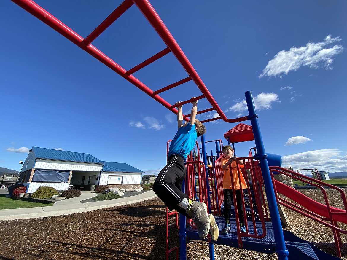 STEM Charter students Paxton (left) and Ryan (right) play on the monkey bars at Rathdrum's newly finished Majestic Park in-between soccer games. (MADISON HARDY/Press)
