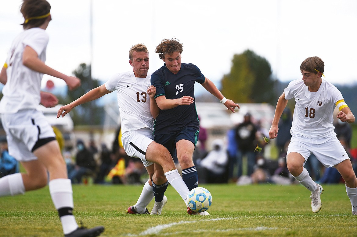 Glacier’s Braden Nitschelm (25) tries to dribble through Helena Capital defenders Eli Voss (13) and Auggie Tupper (18) in the first half at Glacier High School on Saturday. (Casey Kreider/Daily Inter Lake)