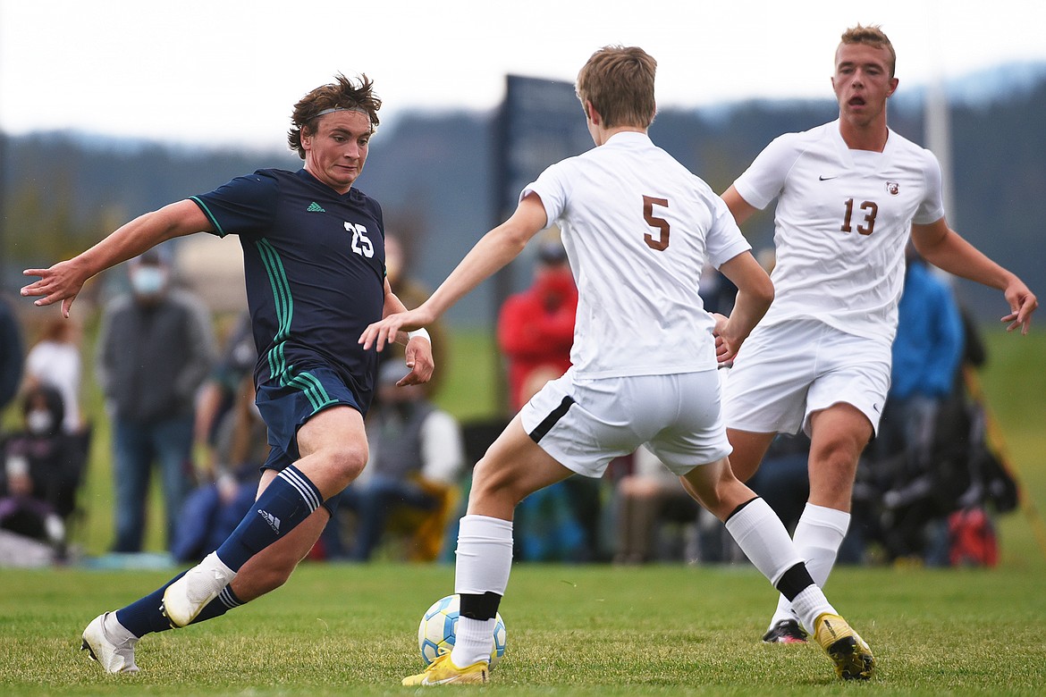 Glacier’s Braden Nitschelm (25) moves the ball upfield against Helena Capital defenders Luke Kailey (5) and Eli Voss (13) at Glacier High School on Saturday. (Casey Kreider/Daily Inter Lake)