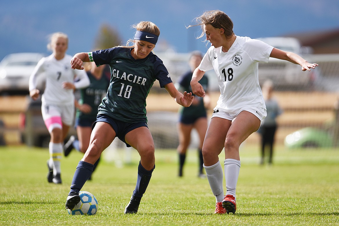 Glacier’s Madison Becker (18) works the ball upfield against Helena Capital’s Lauren Hoxie (18) at Glacier High School on Saturday. (Casey Kreider/Daily Inter Lake)