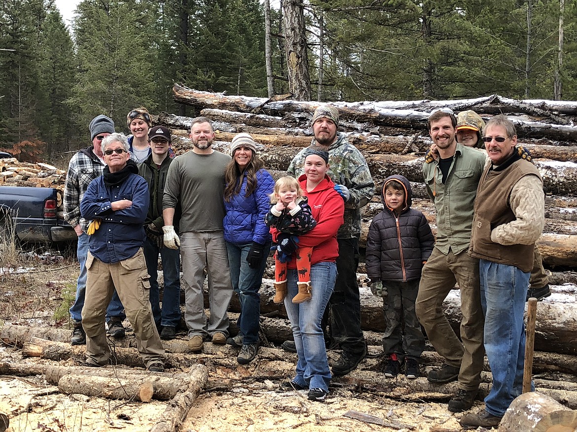 Firewood Rescue volunteers pose at a log deck donation in Priest River.
