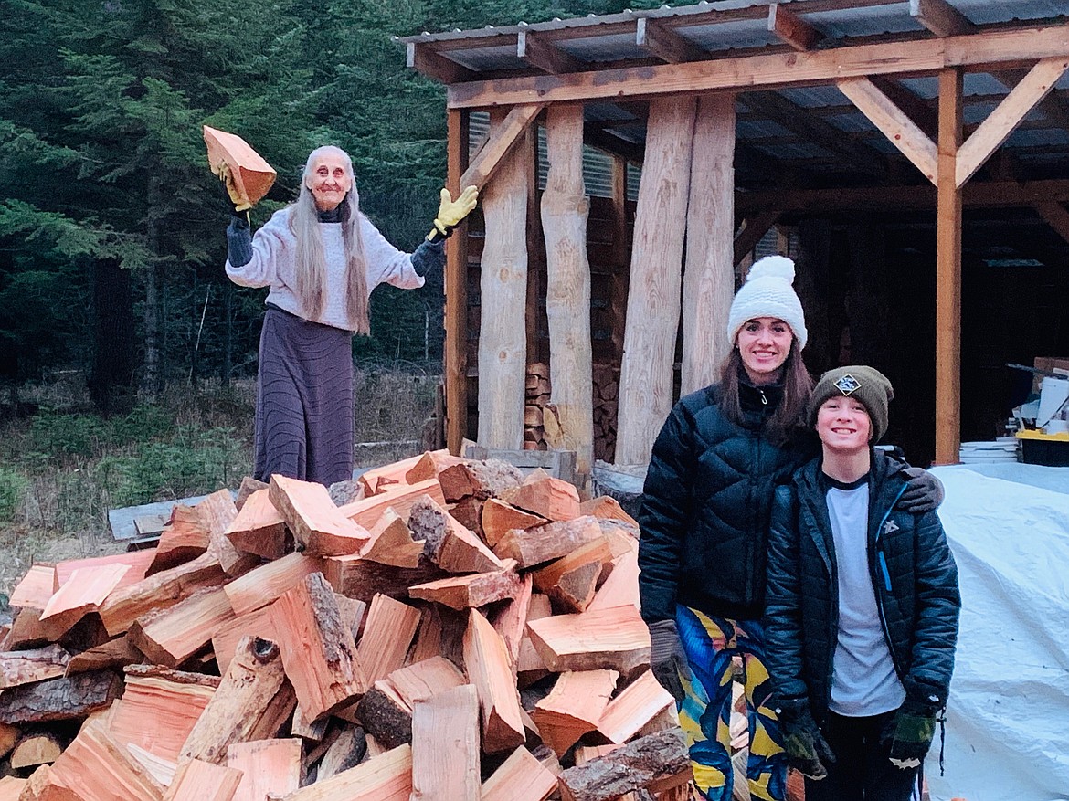 A 70-year-old Newport woman poses with Mel Dick’s grandchildren and her firewood from Firewood Rescue.