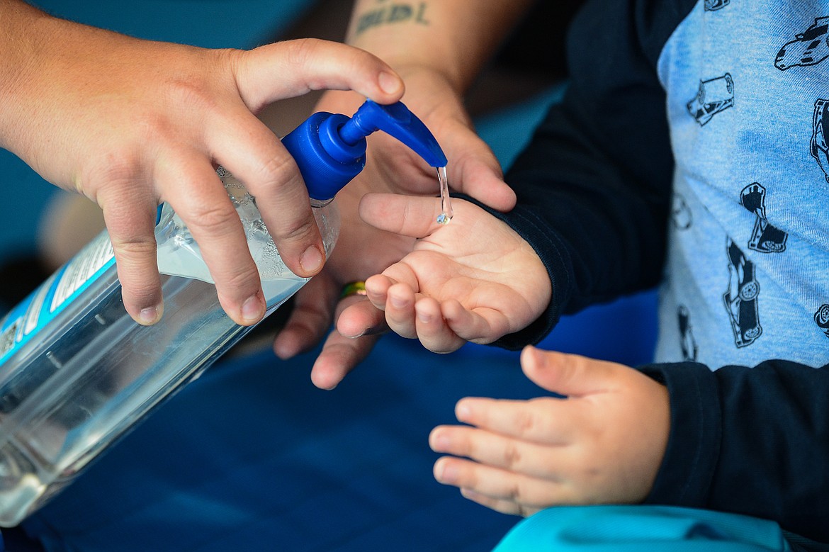 Brittney Malley sanitizes a child's hands at Scribbles Drop In Playcare in Kalispell on Tuesday, Sept. 29. (Casey Kreider/Daily Inter Lake)