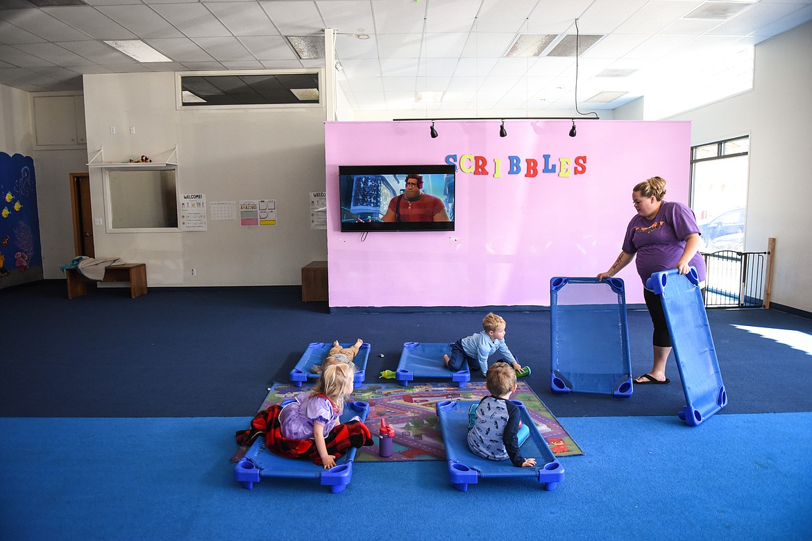 Brittney Malley lays out cots while kids watch a movie at Scribbles Drop  In Playcare in Kalispell in this file photo. (Casey Kreider/Daily Inter Lake FILE)