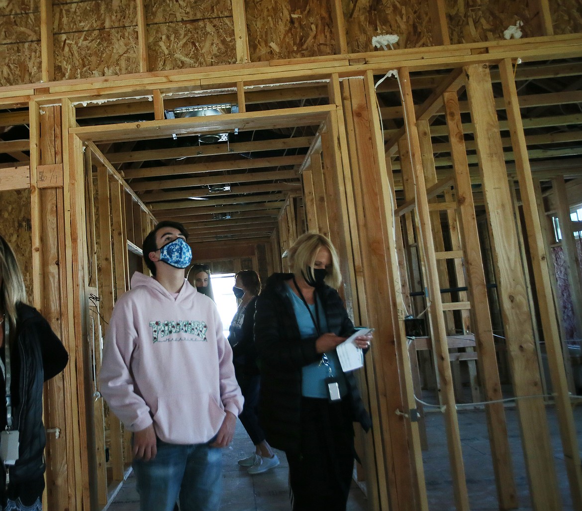 Eighth-grader Morgan Dalton inspects the interior construction of a home in progress on Descartes Drive in Coeur d'Alene Place on Tuesday morning. He and his classmates are learning all about the housing industry.