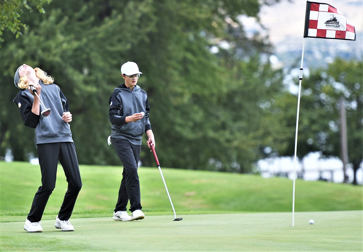Carson Hupka of Polson reacts after missing a putt as teammate Torrin Ellis prepares to line up his next shot on the No. 10 green Saturday. (Scot Heisel/Lake County Leader)