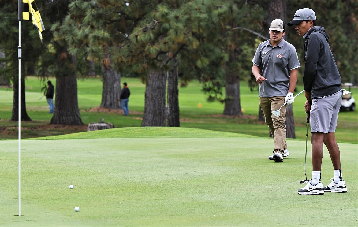 Ronan's Dillon Pretty On Top hits a putt on No. 18 in front of teammate Sage Coffman during the 2020 Western A divisional tournament at Polson Bay Golf Course. (Scot Heisel/Lake County Leader)