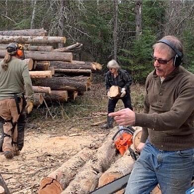 From left to right: Mike Nunke, Claudia Carrier and Paul Krames work cutting logs.