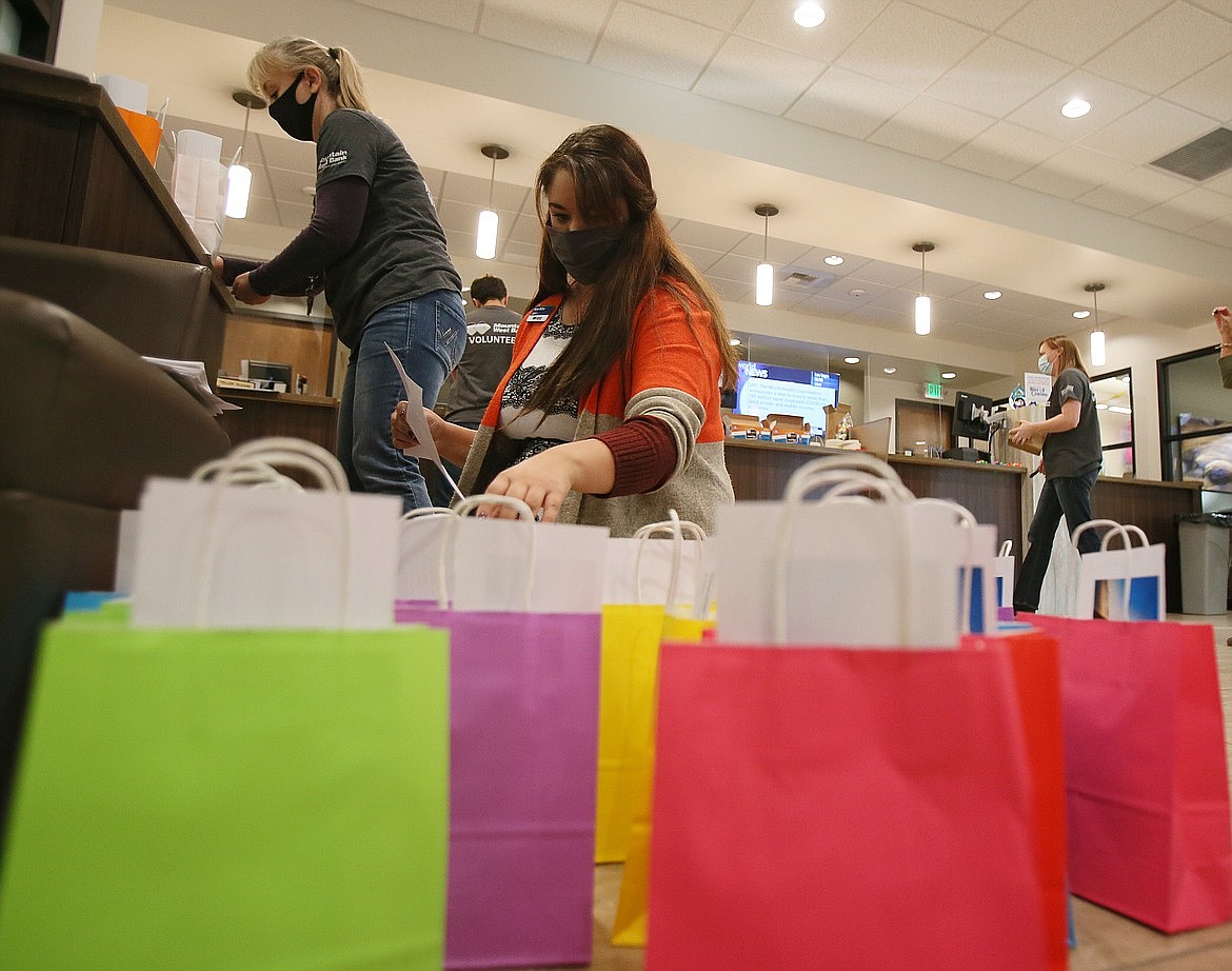 (photo Courtesy of CDA Press)

Bank trainer Kara Miller stuffs bags with instructions for parents Tuesday morning as she and her colleagues prepare project kits for the annual Day of Caring, a community volunteer day led by United Way.