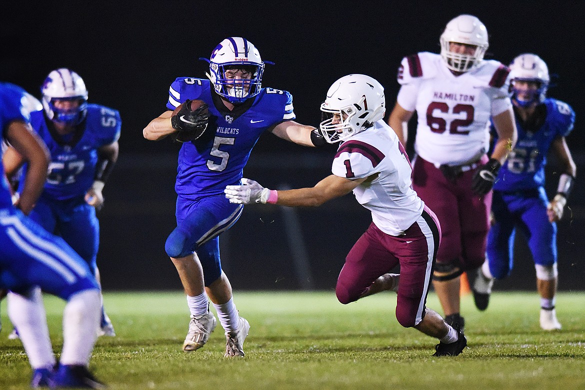 Columbia Falls running back Isaiah Roth (5) extends a stiff-arm to Hamilton defensive back Ben Rooney (1) in the third quarter at Satterthwaite Memorial Field in Columbia Falls on Friday. (Casey Kreider/Daily Inter Lake)