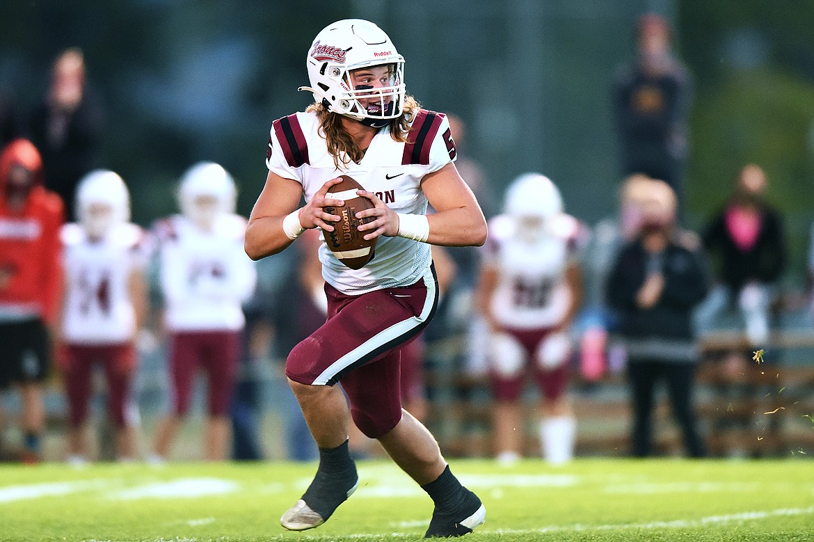 Hamilton quarterback Tyson Rostad (5) rolls out to pass in the first half against Columbia Falls at Satterthwaite Memorial Field in Columbia Falls on Friday. (Casey Kreider/Daily Inter Lake)