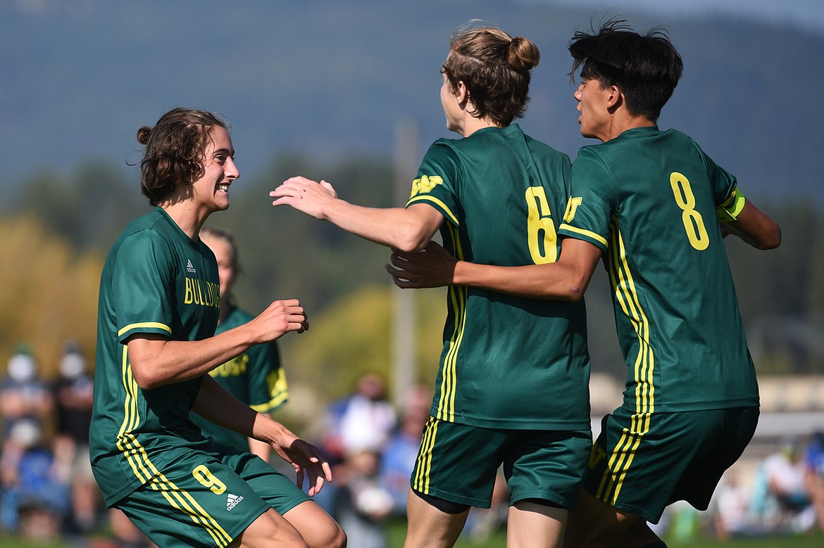 Whitefish’s Gabe Menicke (9), left, celebrates with Darby McCarthy (6) and Brandon Mendoza (8) after a second half goal by Menicke  against Columbia Falls at Smith Fields in Whitefish on Saturday. (Casey Kreider/Daily Inter Lake)