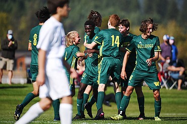 Whitefish teammates celebrate with Marvin Kimera (22) after his second half goal against Columbia Falls at Smith Fields in Whitefish on Saturday. (Casey Kreider/Daily Inter Lake)