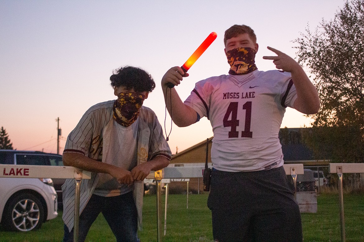 Moses Lake High School football players Leo Cortez and Reise Raymond had the chance to catch up as they helped out with parking at the Friday Night Football Flashback event at Lions Field on Friday, Oct. 2.