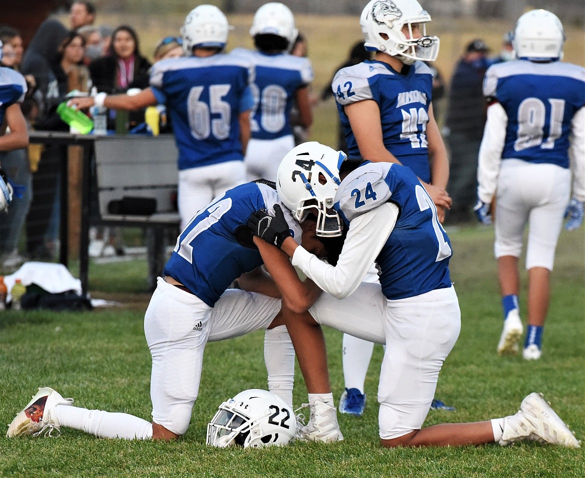 John Komotios, left, and Cedric McDonald kneel together on the sideline before kickoff. (Scot Heisel/Lake County Leader)