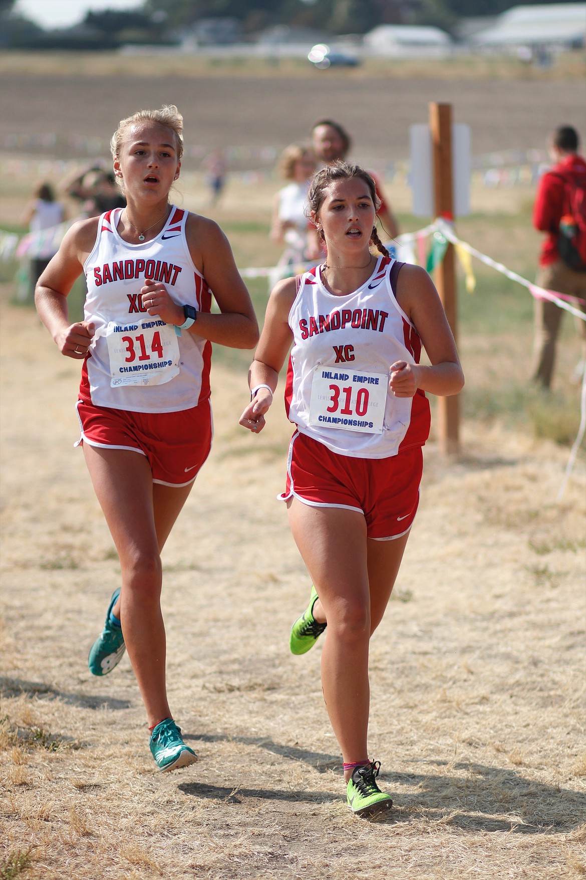 Sophomore Ara Clark (left) and junior Megan Oulman run side-by-side during Saturday's Inland Empire Challenge.