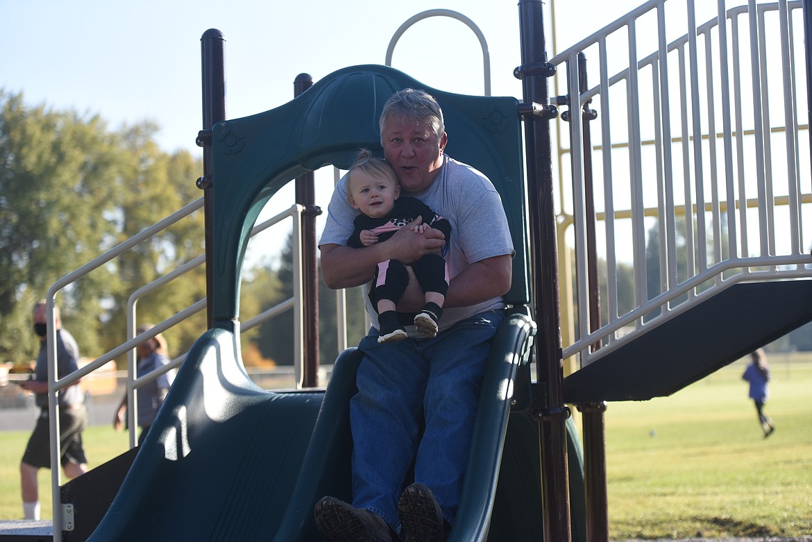 Jay Graham and granddaughter Everly Graham take an inaugural slide at the new Libby Elementary School playground. The playground was dedicated to Judy Graham, wife of Jay Graham, grandmother of Everly Graham and longtime teacher who passed away in 2019.