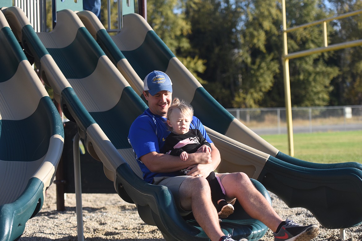 Justin Graham and daughter Everly Graham take an inaugural slide at the new Libby Elementary School playground. The playground was dedicated to Judy Graham, mother of Justin Graham, grandmother of Everly Graham and longtime teacher who passed away in 2019.