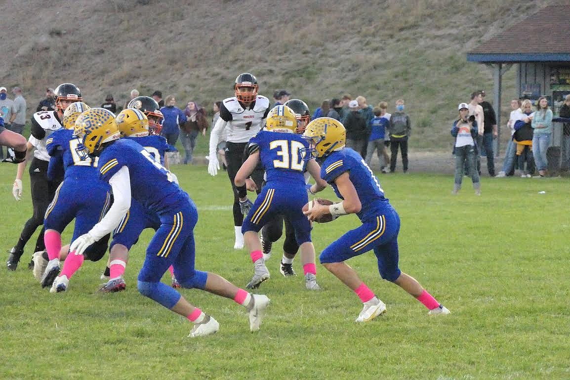 Thompson Falls quarterback Roman Sparks looks for room to run against Plains in last week’s game. Sparks threw two touchdown passes and ran for another in a 51-6 homecoming win. (Chuck Bandel/Valley Press)