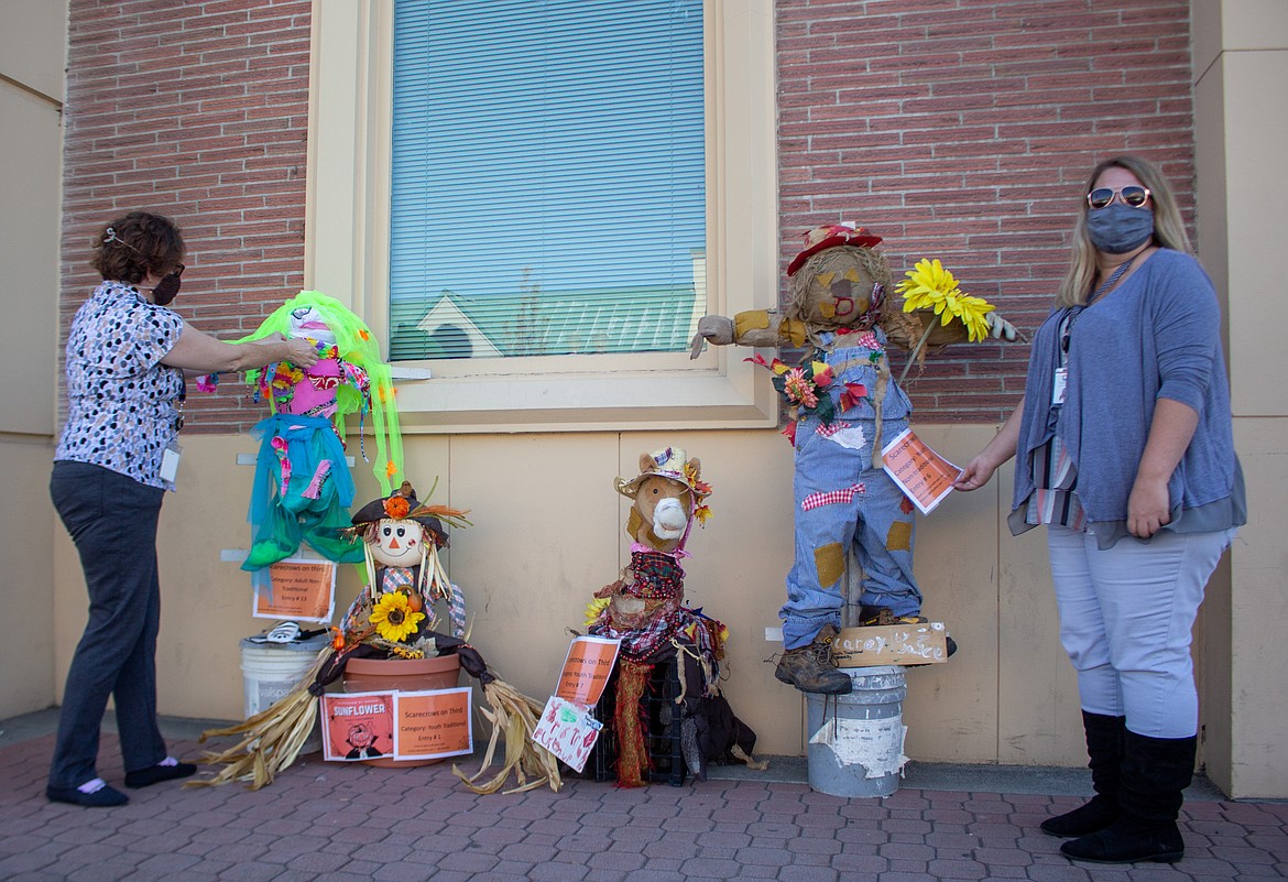 Dollie Boyd, left, and Jenni Shelton, right, from the Moses Lake Museum & Art Center set up a pair of scarecrow submissions for the Scarecrows on Third event in partnership with the Downtown Moses Lake Association.