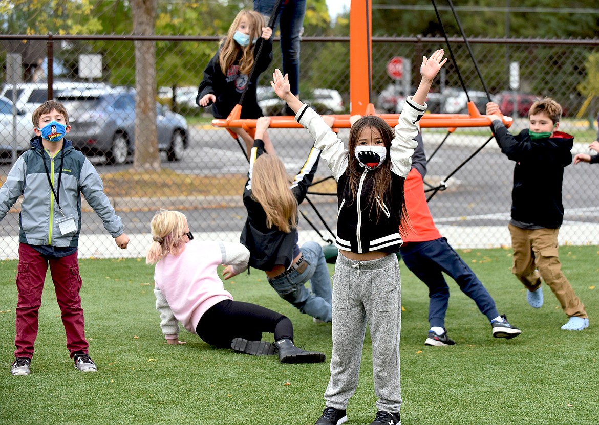 Muldown Elementary fourth graders James Weyh and Ella Siddall-Kim stand out from the crowd as their fellow students play on the new equipment  at the school. (Whitney England/Whitefish Pilot)