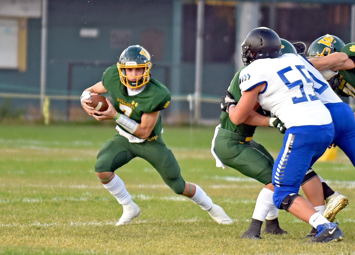 Whitefish quarterback Fynn Ridgeway looks to advance the ball upfield in a game against Corvallis Friday night in Whitefish. (Whitney England/Whitefish Pilot)
