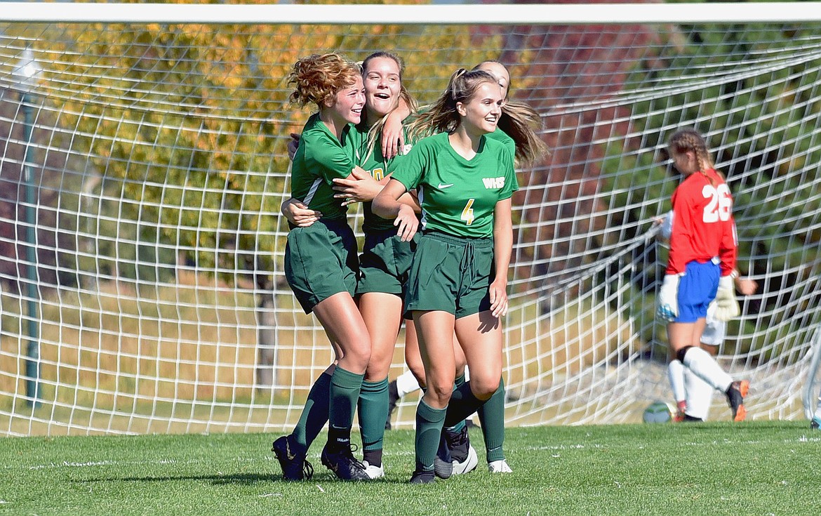 Whitefish players Brooke Roberts, Ali Hirsch and Sophie Olson celebrate a goal scored by Hirsch in the first half against Columbia Falls at Smith Fields on Saturday. (Whitney England/Whitefish Pilot)