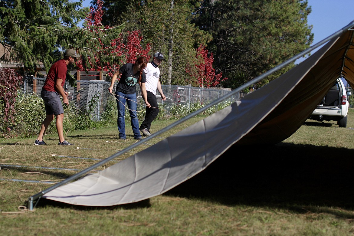 From left to right: Zach Vollmer, Owner of Alpine Shop, Chloe Davis, outdoor educator for KLT, and Jaymes Hansen, an employee at Alpine Shop, work to set up a tent Tuesday afternoon at Farmin-Stidwell Elementary School.