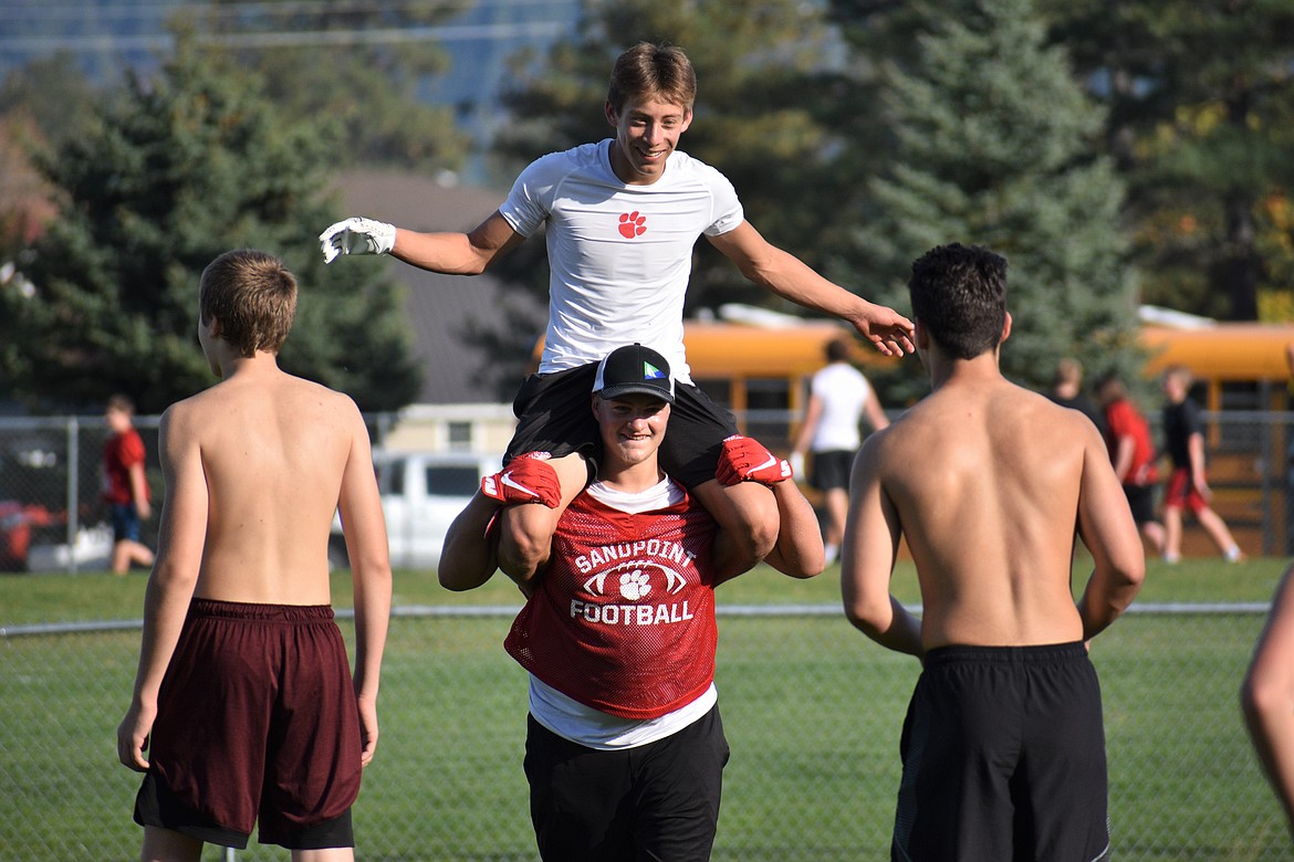 Adam Bucholtz (top) receives a piggy back ride from Brandon Sargent during Wednesday's two-hand touch football at SHS.