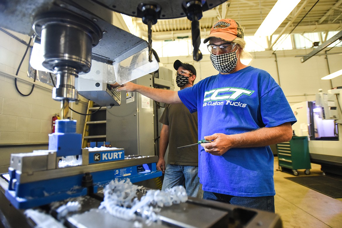 Brian Hollingsworth, right, and Jake Biondich practice cutting an internal spline on a piece of plastic with a milling machine at the Occupational Trades building at Flathead Valley Community College in Kalispell on Tuesday, Oct. 6. (Casey Kreider/Daily Inter Lake)
