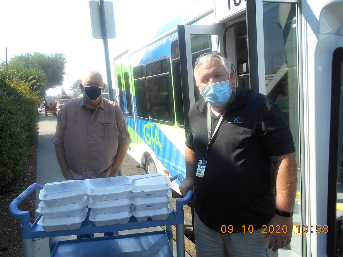 Grant Transit Authority (GTA) bus driver Jim Ackley (right) and Ephrata Senior Center representative John Daling load meals on to a GTA bus for delivery.