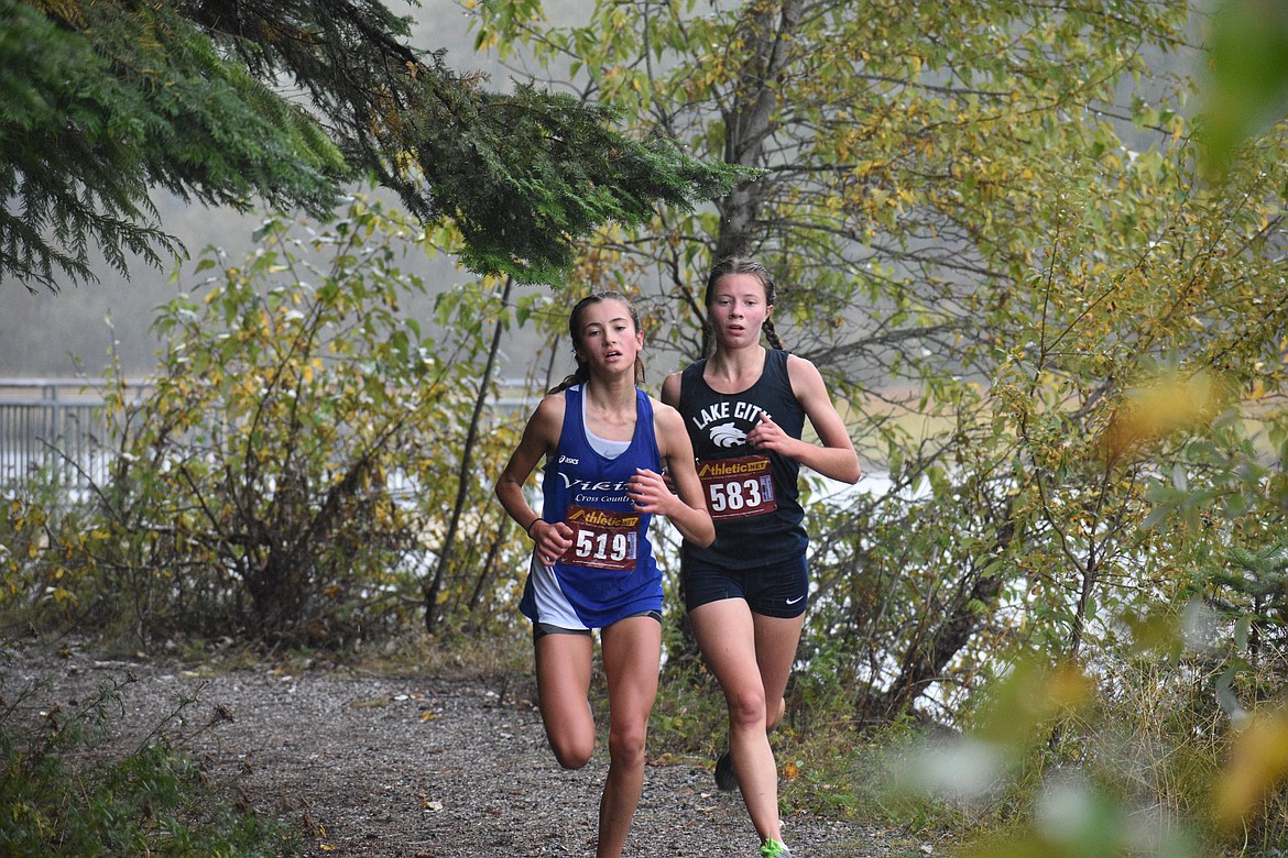 DYLAN GREENE/Bonner County Daily Bee
Elliana Rietze, left, of Coeur d'Alene, and Angelyca Chapman of Lake City run side-by-side during Saturday's Sandpoint Invitational at Riley Creek Campground.