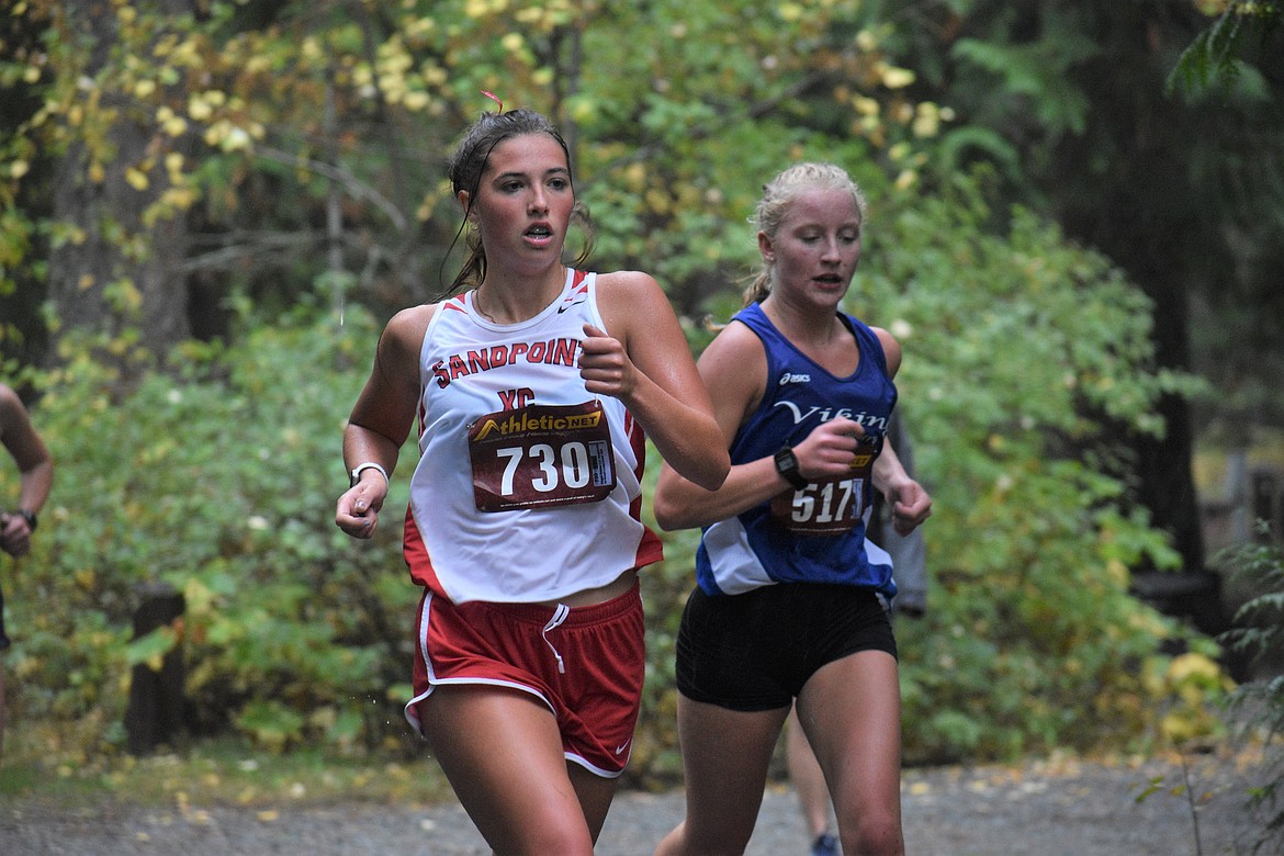 Junior Megan Oulman (left) passes a Coeur d'Alene runner during Saturday's William Johnson Sandpoint Invitational.