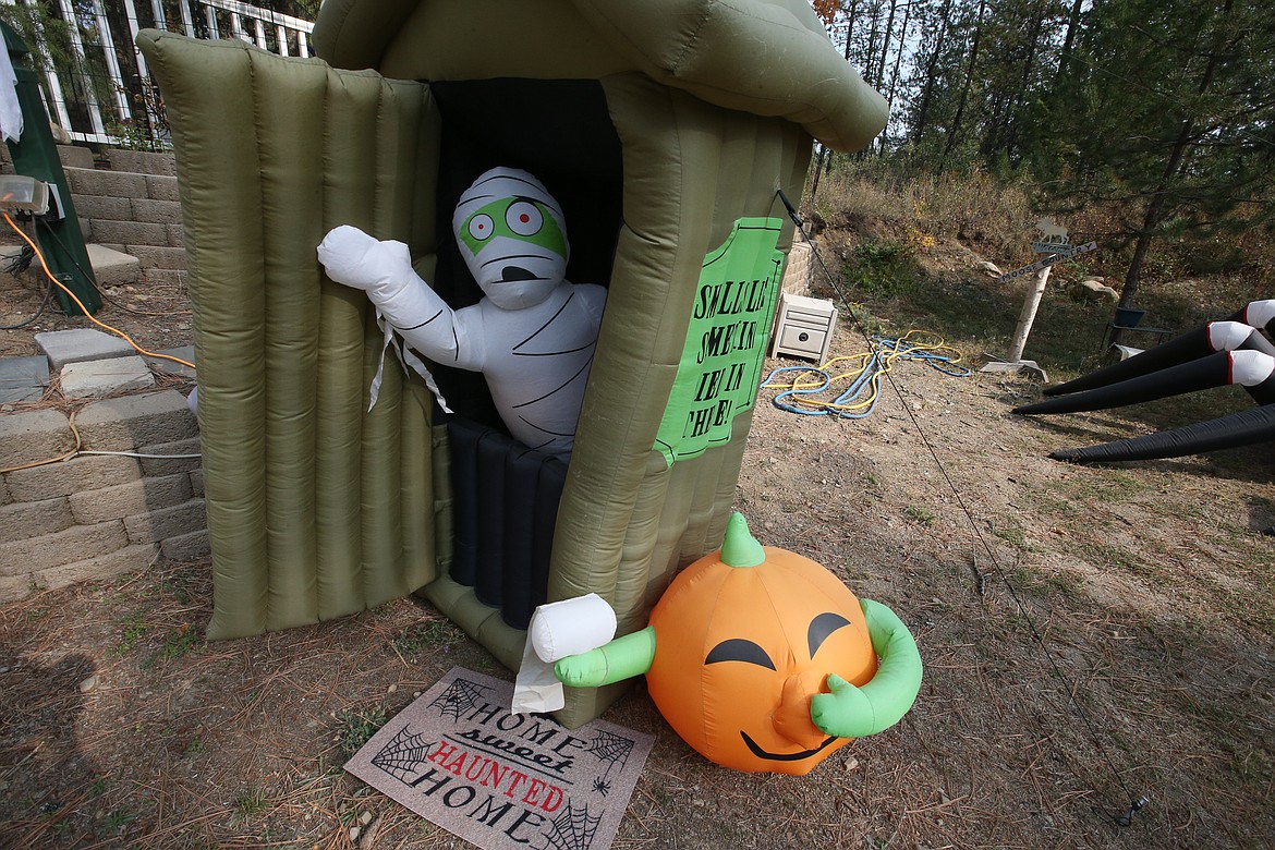 A Halloween mummy peeks from the outhouse at the Spirit Lake home of Mike and Debbie Bendig.