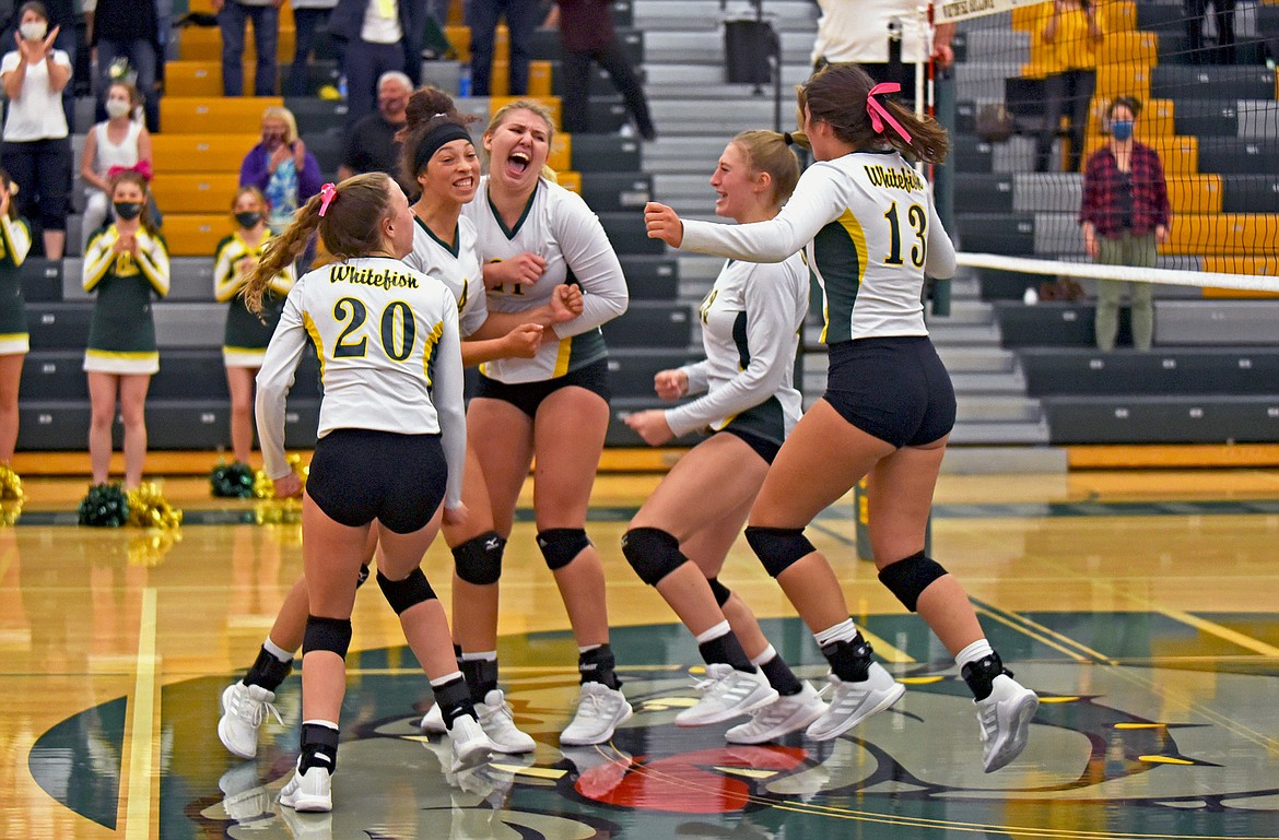 Whitefish volleyball players celebrate winning the third set in a match against Polson Tuesday, Oct. 6. (Whitney England/Whitefish Pilot)