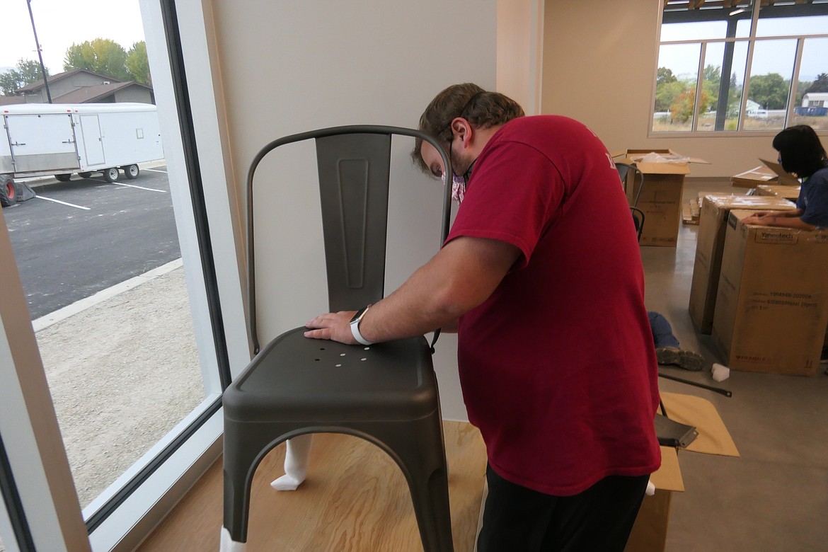 Jimmy Ray Stagg, teen coordinator for the Ronan club, assembles chairs. (Carolyn Hidy/Lake County Leader)