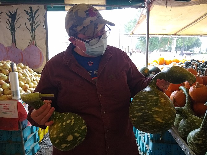 Liz Poteet shows off a pair of swan gourds, an heirloom gourd variety that many customers have never encountered before arriving at Poteet Produce.