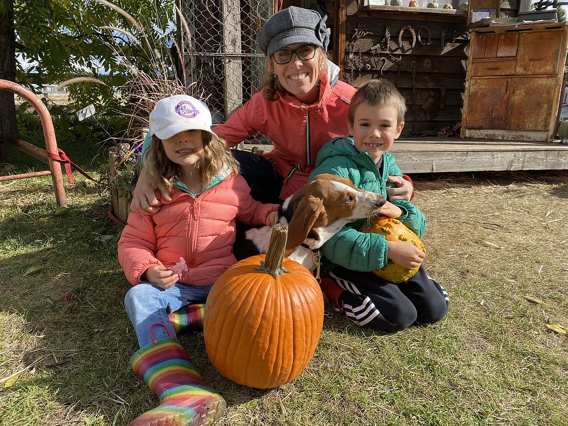 Peter, Piper and mom Kendra Adams enjoy a day in the sun with Daisy the puppy at Prairie Home Farm in Coeur d'Alene Wednesday afternoon. (MADISON HARDY/Press) From Left: Piper, Kendra, Peter.