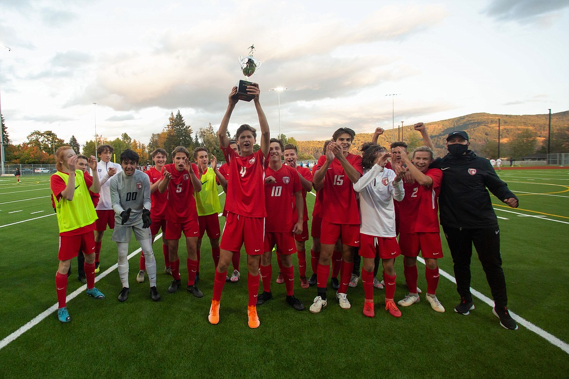 Sophomore Evan Dickinson (center) raises the district championship trophy as his teammates look on following Thursday's 3-0 win over Moscow.