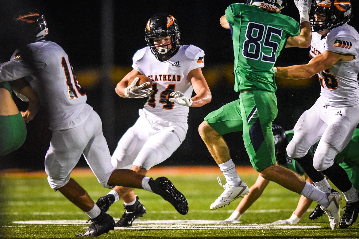 Flathead running back Alec Thomas (14) looks for room to run against the Glacier defense in the first half during crosstown football at Legends Stadium on Friday. (Casey Kreider/Daily Inter Lake)