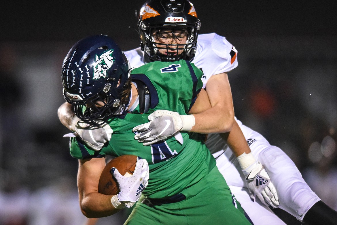 Glacier tight end Luke Bilau (4) is brought down by Flathead defensive back Nicolas Gustafson (8) in the second quarter during crosstown football at Legends Stadium on Friday. (Casey Kreider/Daily Inter Lake)